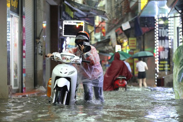 Hà Nội: Hàng loạt tuyến phố ngập nặng sau cơn mưa lớn, người dân bì bõm lội trong nước - Ảnh 16.