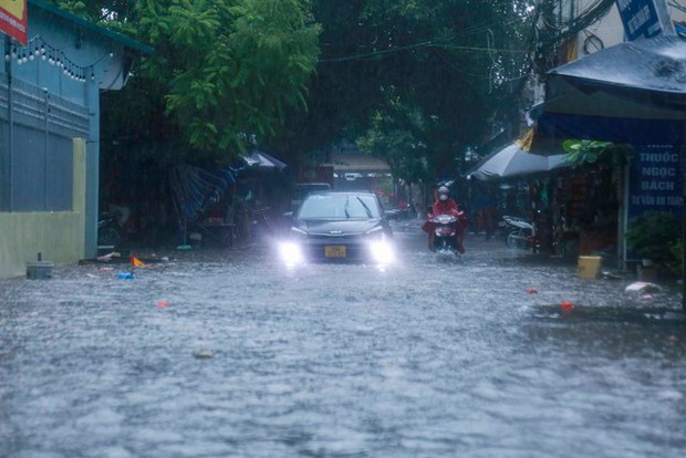 Hà Nội: Hàng loạt tuyến phố ngập nặng sau cơn mưa lớn, người dân bì bõm lội trong nước - Ảnh 1.