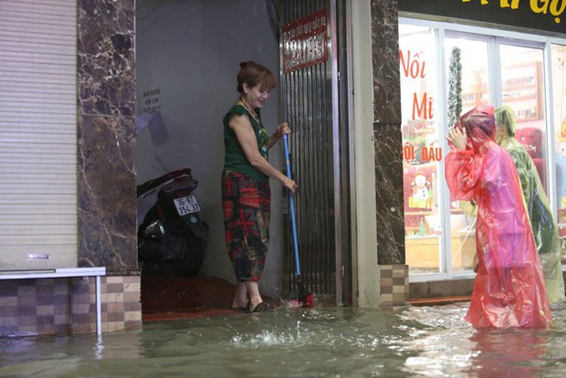 Hà Nội: Hàng loạt tuyến phố ngập nặng sau cơn mưa lớn, người dân bì bõm lội trong nước - Ảnh 12.