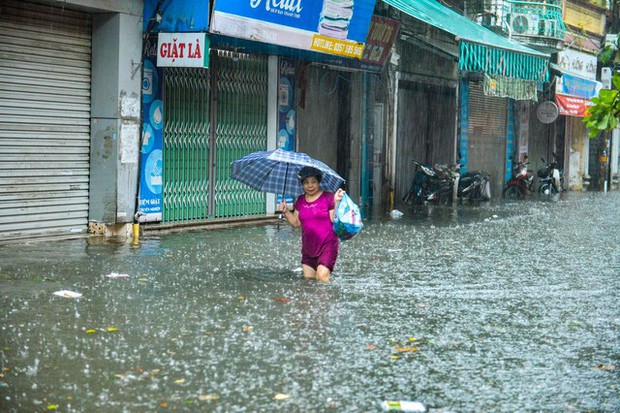 Hà Nội: Hàng loạt tuyến phố ngập nặng sau cơn mưa lớn, người dân bì bõm lội trong nước - Ảnh 9.