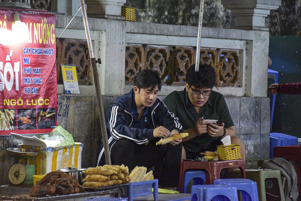 Người Hà Nội mặc áo rét, lấy khăn quàng, ăn ngô nướng trong gió lạnh đầu mùa - Ảnh 8.