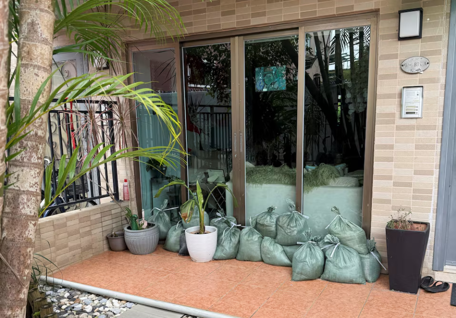 Các thành phố “đóng cửa”, nín thở trước siêu bão Ragasa: Người dân dán chặt cửa kính, chặn bao cát trước nhà, càn quét siêu thị tích trữ đồ- Ảnh 8.