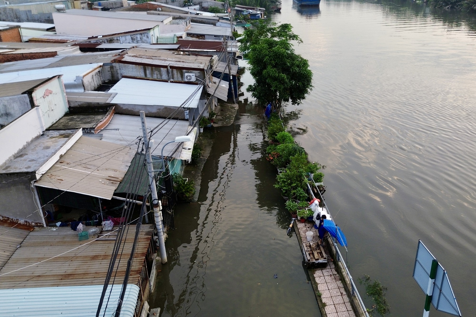 Cả ngày nắng oi, tối một nơi ở TP.HCM lại ngập như sông: Nước tràn vào nhà, người dân lại kê đồ