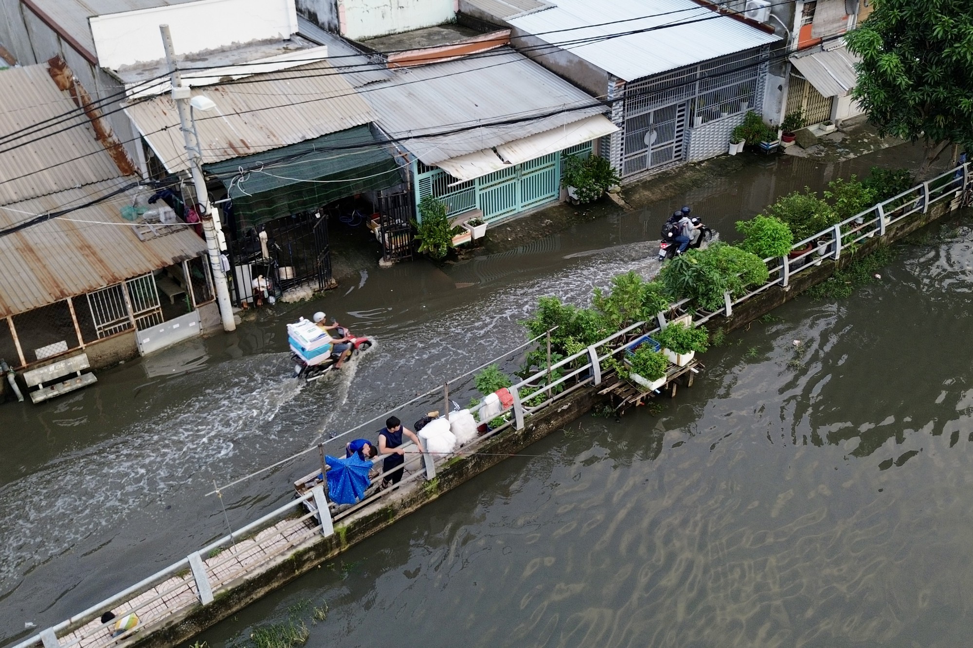 Cả ngày nắng oi, tối một nơi ở TP.HCM lại ngập như sông: Nước tràn vào nhà, người dân lại kê đồ