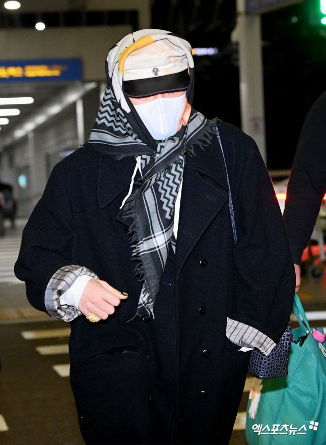 Ngay lúc này: G-Dragon thời trang phang thời tiết, trùm khăn hoa cúc kín mít khởi hành sang Việt Nam - Ảnh 1.